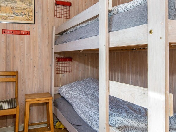 A bunk bed with a wooden frame, a small wooden stool, and a chair. - 6 Person Holiday Home in Hemmet (Hemmet)