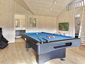 A pool table with balls and cues, a television, and a ladder in a room with wooden walls and a tiled floor. - 5 Star Holiday Home in Idestrup (Idestrup)