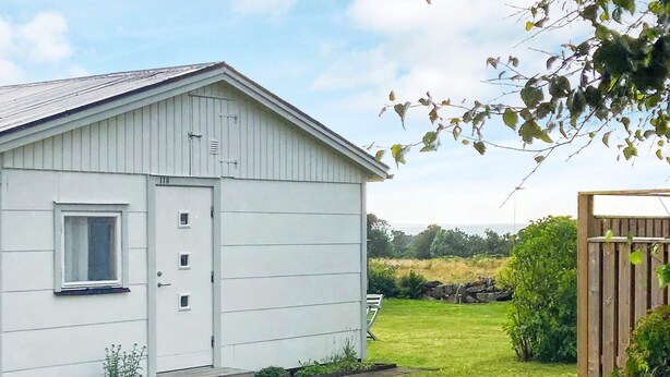 A single-story white building with a gabled roof, a small window, and a door. - 4 Person Holiday Home in Falkenberg (Falkenberg)