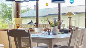 A dining area with a table, chairs, and a view of the outside. - 4 Person Holiday Home in Falkenberg (Falkenberg)
