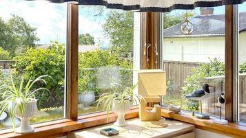 Una habitación con un ventanal grande, un escritorio de madera y una planta en maceta.