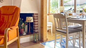 Una habitación acogedora con chimenea, una mesa de comedor con sillas y una ventana con vistas al exterior.