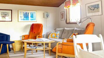 A living room with a sofa, chairs, a coffee table, and a lamp.