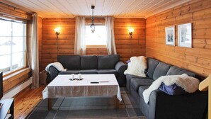 A cozy log cabin interior with a sofa set, a coffee table, and a fireplace. - 10 Person Holiday Home in Aseral (Aseral)