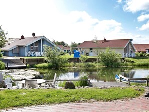 A lakeside property with a dock, a small boat, and a pavilion.