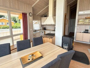 A modern kitchen with a stove, sink, and dining area with a table and chairs.