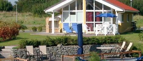 A lakeside property with a covered patio, outdoor seating, and a boat dock.