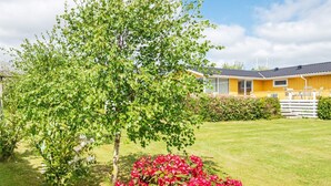 A yellow building with a well-maintained lawn and a tree in the foreground. - 6 Person Holiday Home in Hejls (Hejls)