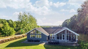 A modern house with a large patio area and a covered outdoor seating space. - Quaint Holiday Home in Fur Jutland near Fjord (Glesborg)