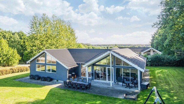 A modern two-story house with a large glass patio area, a covered outdoor kitchen, and a well-maintained lawn. - Quaint Holiday Home in Fur Jutland near Fjord (Glesborg)