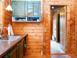 A wooden interior with a kitchen area, including a sink, cabinets, and a countertop. - 4 Person Holiday Home in Farvang (Farvang)