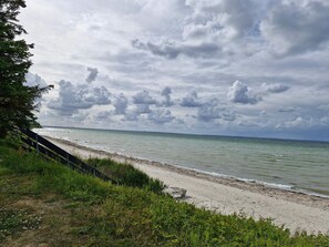 A beach with a grassy foreground and a cloudy sky. - 5 Star Holiday Home in Nordborg (Nordborg)