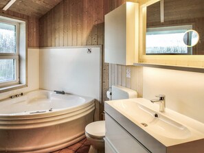 Bathroom features a bathtub, toilet, and sink with a window above.