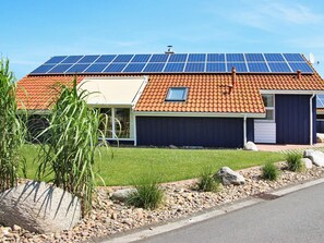 A modern house with a solar panel roof, a garage, and a well-maintained garden. - Holiday Home in Otterndorf (Otterndorf)