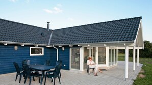 A house with a covered patio, a chimney, and a window overlooking the yard. - Fabulous Holiday Home in Rodby Denmark near Sea (Rodby)