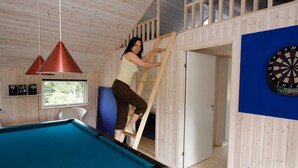 A room with a pool table, a dartboard, and a wooden ladder leading to a loft area. - Fabulous Holiday Home in Rodby Denmark near Sea (Rodby)