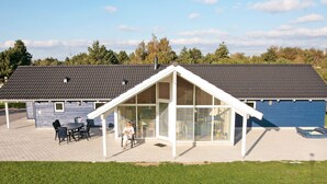 A modern building with a covered patio area, a large window, and a flat roof. - Fabulous Holiday Home in Rodby Denmark near Sea (Rodby)