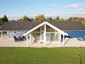 A modern building with a covered patio area, a large window, and a flat roof. - Fabulous Holiday Home in Rodby Denmark near Sea (Rodby)