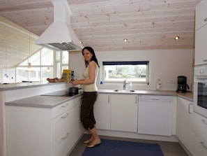 A kitchen with a window, a sink, and a stove.