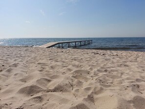 A sandy beach with a wooden pier extending into the water. - Fabulous Holiday Home in Rodby Denmark near Sea (Rodby)