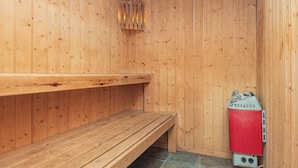 Puisesta materiaalista rakennettu saunatila, jossa on lauteet ja kiuas.