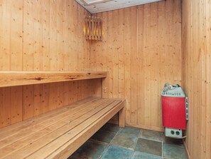 Ein Raum für eine Holzsauna mit Bänken und einer Saunaheizung.
