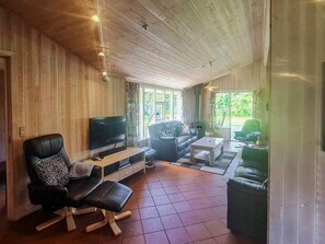 A cozy living room with a television, leather chairs, a coffee table, and a fireplace. - 4 Star Holiday Home in Nordborg (Nordborg)