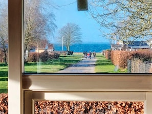Un sentier qui mène à un plan d’eau où l’on voit des personnes se promener.