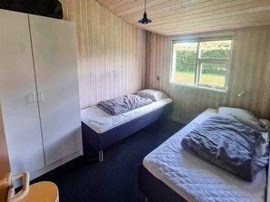 A room with two beds, a wardrobe, and a window. - 4 Star Holiday Home in Nordborg (Nordborg)