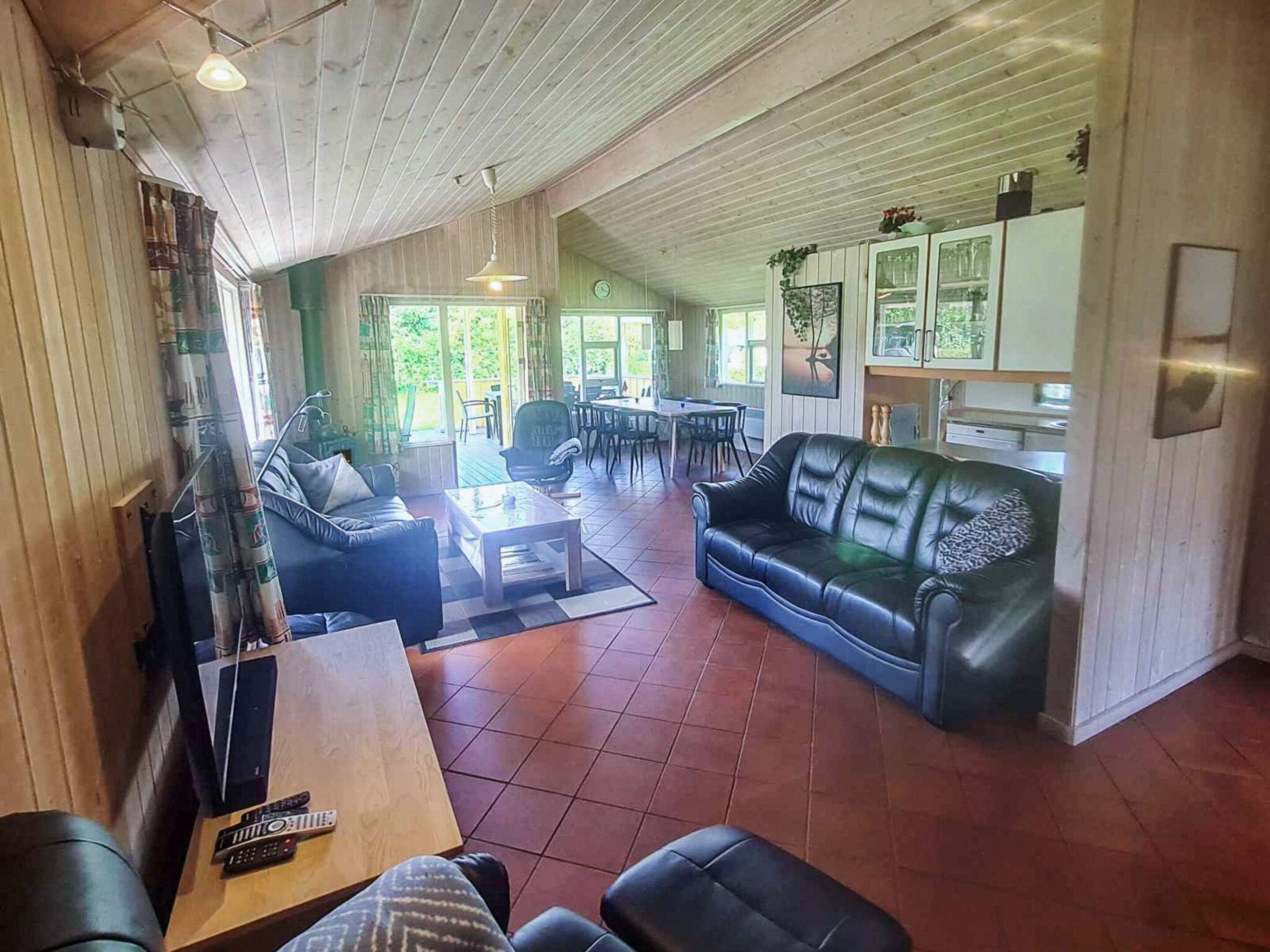 Un vaste espace de vie comprenant un canapé, une table basse et une table à manger avec des chaises.