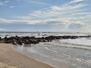 A beach with a rocky shoreline and waves.