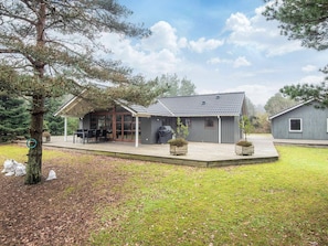 A residential property with a covered patio, a barbecue area, and a small shed.