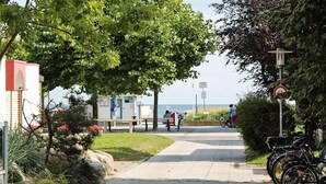 A pathway with bicycles, benches, and a view of the sea. - Holiday Home in Grossenbrode (Grossenbrode)