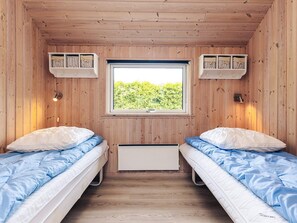 A room with two beds, a window, and wooden walls. - Attractive Holiday Home in Vaggerlose near Sea (Idestrup)