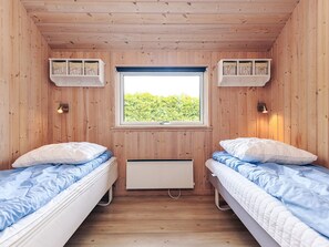 A cabin room with two beds, a window, and wooden walls. - Attractive Holiday Home in Vaggerlose near Sea (Idestrup)