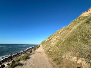 A coastal path with a clear view of the sea and a grassy hillside. - 4 Star Holiday Home in Hjorring (Hjørring)