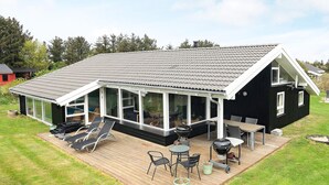 A modern house with a large deck, outdoor seating, and a covered patio area. - 4 Star Holiday Home in Hjorring (Hjørring)