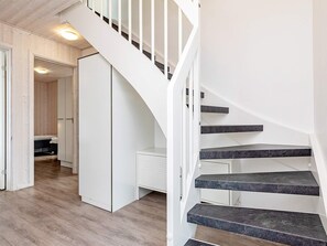 A modern interior with a spiral staircase, wooden flooring, and white cabinetry. - Holiday Home in Wendtorf (Wendtorf)