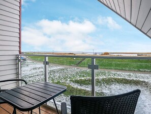 A balcony with a view of a grassy field and a body of water. - Holiday Home in Wendtorf (Wendtorf)