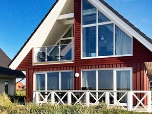 A two-story house with a red exterior, white trim, and multiple windows. - Holiday Home in Wendtorf (Wendtorf)