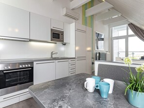 A modern kitchen with a built-in oven, microwave, and stainless steel appliances. - Holiday Home in Wendtorf (Wendtorf)