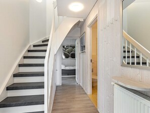 A staircase leading to a bedroom with a bed, a window with a view of the sea, and a wooden floor. - Holiday Home in Wendtorf (Wendtorf)