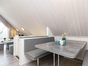 A modern loft-style dining area with a built-in bench and a marble table.