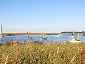 A calm water body with various boats, including a sailboat and several rowboats, anchored in the foreground. - Holiday Home in Wendtorf (Wendtorf)