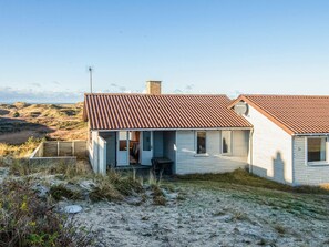 A single-story house with a sloped roof, a visible chimney, and a small porch area. - 6 Person Holiday Home in Henne (Henne)