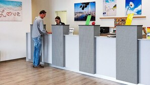 A reception area with a counter, a desk, and a wall with artwork. - Holiday Home in Grossenbrode (Grossenbrode)