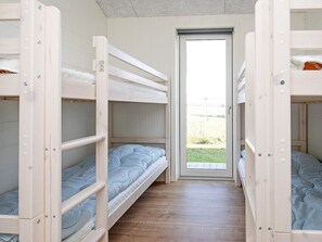 A bunk bed room with a door leading outside.