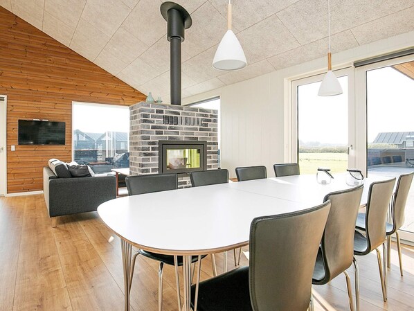 A modern interior with a fireplace, dining table, and seating area.