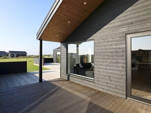A modern building with a wooden deck, large windows, and a view of the surrounding area. - 12 Person Holiday Home in Lokken-by Traum (Lokken)