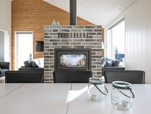 A modern living room with a fireplace, a television, and a table with candles.
